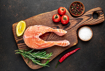 raw salmon steak with spices on a stone background