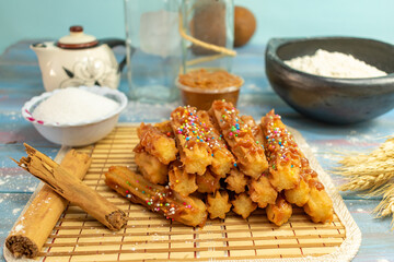 Typical Spanish churros covered with arequipe and colored sparks