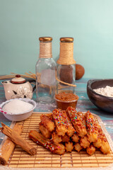 Still life with typical Spanish churros covered with chocolate chips and arequipe