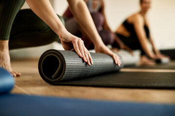 Close-up of  female athlete preparing exercise mat for sports training.