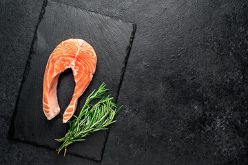 raw salmon steak with spices on a stone background with copy space for your text