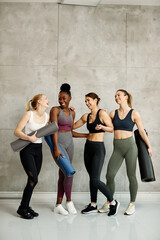 Fototapeta premium Group of diverse athletic women having fun while talking after exercise class at health club.