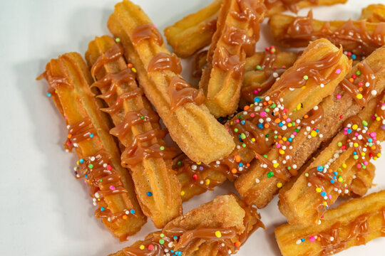 Typical Spanish churros covered with arequipe and colored sparks
