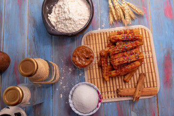 
overhead view of typical Spanish churros and container with guava arequipe covered with colored sparks