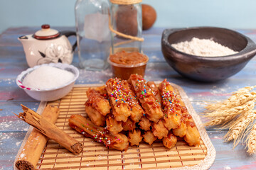 Typical Spanish churros covered with arequipe and colored sparks