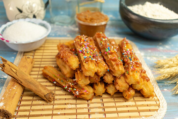 Typical Spanish churros covered with arequipe and colored sparks