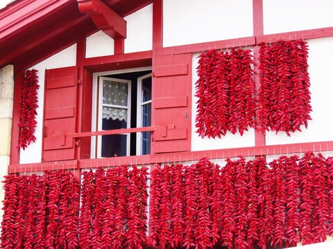 S&eacute;chage traditionnel de tresses de piments d'Espelette rouges sur la fa&ccedil;ade d&rsquo;une maison du village d&rsquo;Espelette, dans le pays basque (France)