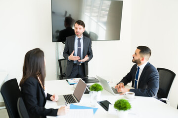 Businessman giving a pep talk to his work team