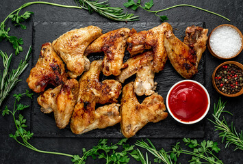 grilled chicken wings with spices on a stone background
