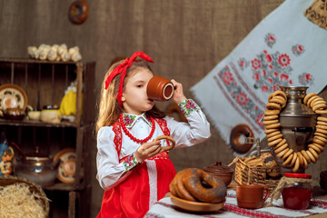 Adorable girl drinking tea from samovar
