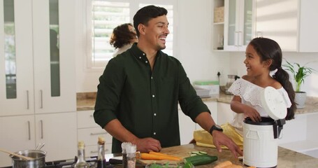 Hispanic parents and daughter cooking and teaching segregating bio trash