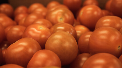 Bright red cherry tomatoes packed together in a cardboard box,  makes it look like a sea of red balls. Food processing and shipment concept photo.
