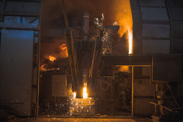 Big steel mill or iron furnace at work. Process of injecting oxygen to produce steel from iron scraps. Sparks flying around and temperature rising.
