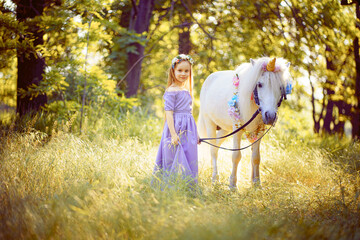 Girl in purple dress hugging white unicorn horse. Dreams come tr