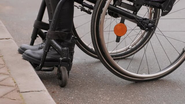 A person with a disability moves along the street in a wheelchair, the border prevents the movement of the wheelchair