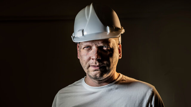 working man construction worker with dirty face looking at camera Close up portrait