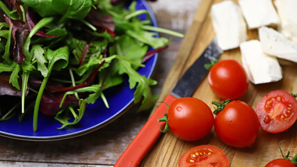 Cooking a healthy salad. Salad, cherry tomatoes, feta.