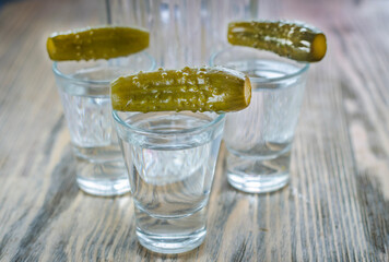 Vodka in a glass and pickled cucumber