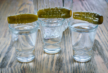 Vodka in a glass and pickled cucumber