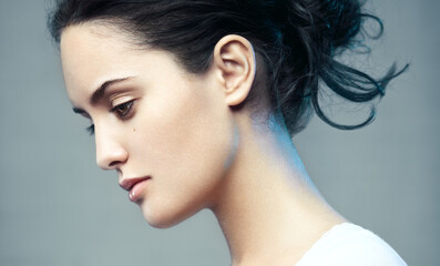 Closeup beauty portrait of a young beautiful brunette woman. Muse. Profile, looking down.