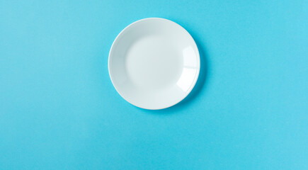 White plate on light blue background.  水色背景上の白いお皿