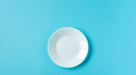 White plate on light blue background.  水色背景上の白いお皿