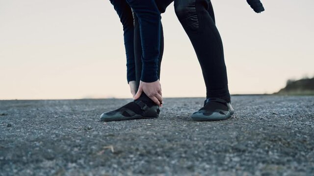 Person Tightening Up Shoes, Getting Ready For A Hike, Pulling Down Pants Over The Shoes. Watchtower In Background.