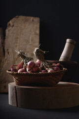 Shallots in a bamboo basket on wooden cutting board with mortar and pestle, Food ingredients in Thai cuisine, Still Life