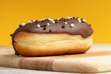 French dessert, eclair, on yellow background.