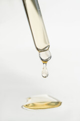 A drop of cosmetic oil falls from the pipette