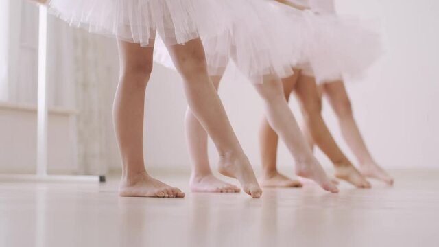 Legs of little ballerins in pose on ballet class