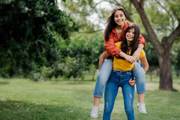 Fototapeta premium candid portrait Female couple playing enjoying a day in the park, smiling Identity without filter. Authentic people. Not binary 