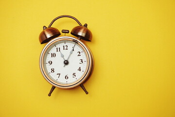 Vintage alarm clock with space copy on yellow background