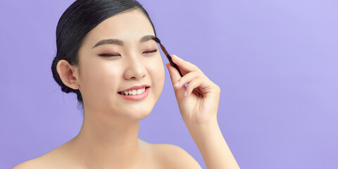 Fototapeta premium beautiful young woman comb her eyebrows with brush