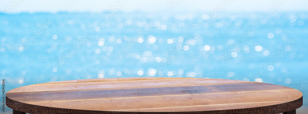 Poster empty round wood table with summer blue sea blur background.copy space for display of product on onl