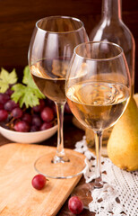 Wine and grapes in vintage setting on wooden table.