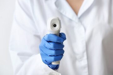 Doctor with infrared thermometer, closeup