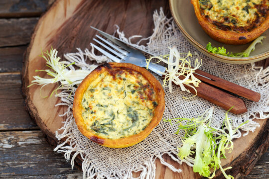 mini quiche com espinafre em uma placa de madeira, estilo r&uacute;stico. 
