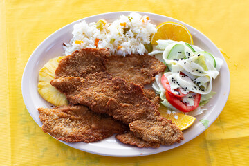 Filete de pescado empanizado. Plato de filete de pescado acompañado con pasta y verduras.
