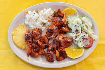 Plato de comida con elementos de amr. Plato de camarones empanizados acompañados de arroz y verduras.