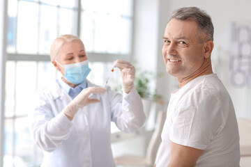 Fototapeta premium Doctor vaccinating patient in clinic