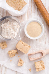 Fresh and dried yeast with baking ingredients on white background