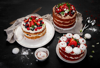 Assorted delicious and colorful homemade cakes with different type of filling on black background.