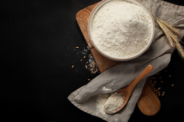 Wheat flour on dark background. Food preparing concept.