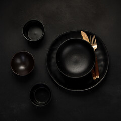 Table setting with a black plates on a black background. Minimalism concept.