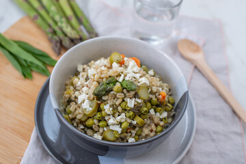 healthy home made barley soup with spring vegetables, wild garlic and asparagus