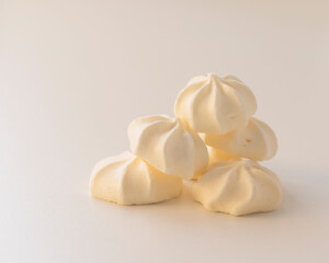 a bunch of cream meringues on a light background