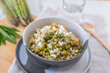 healthy home made barley soup with spring vegetables, wild garlic and asparagus