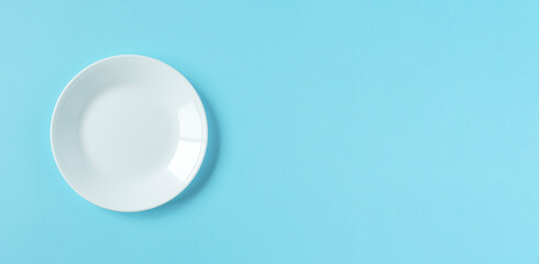 White plate on light blue background. 水色背景上の白いお皿