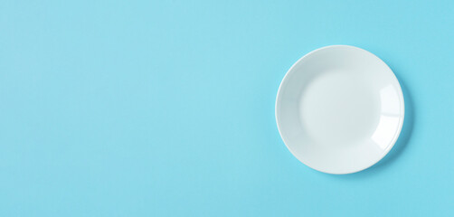 White plate on light blue background. 水色背景上の白いお皿